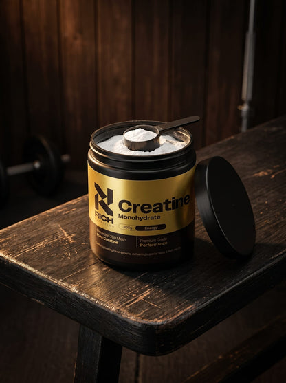 RichNutrition Creatine Monohydrate op donkere gymbank met maatschep